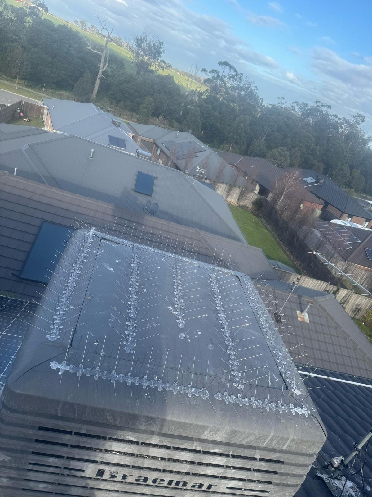 Bird spikes fitted around an evaporative cooler on a Melbourne roof